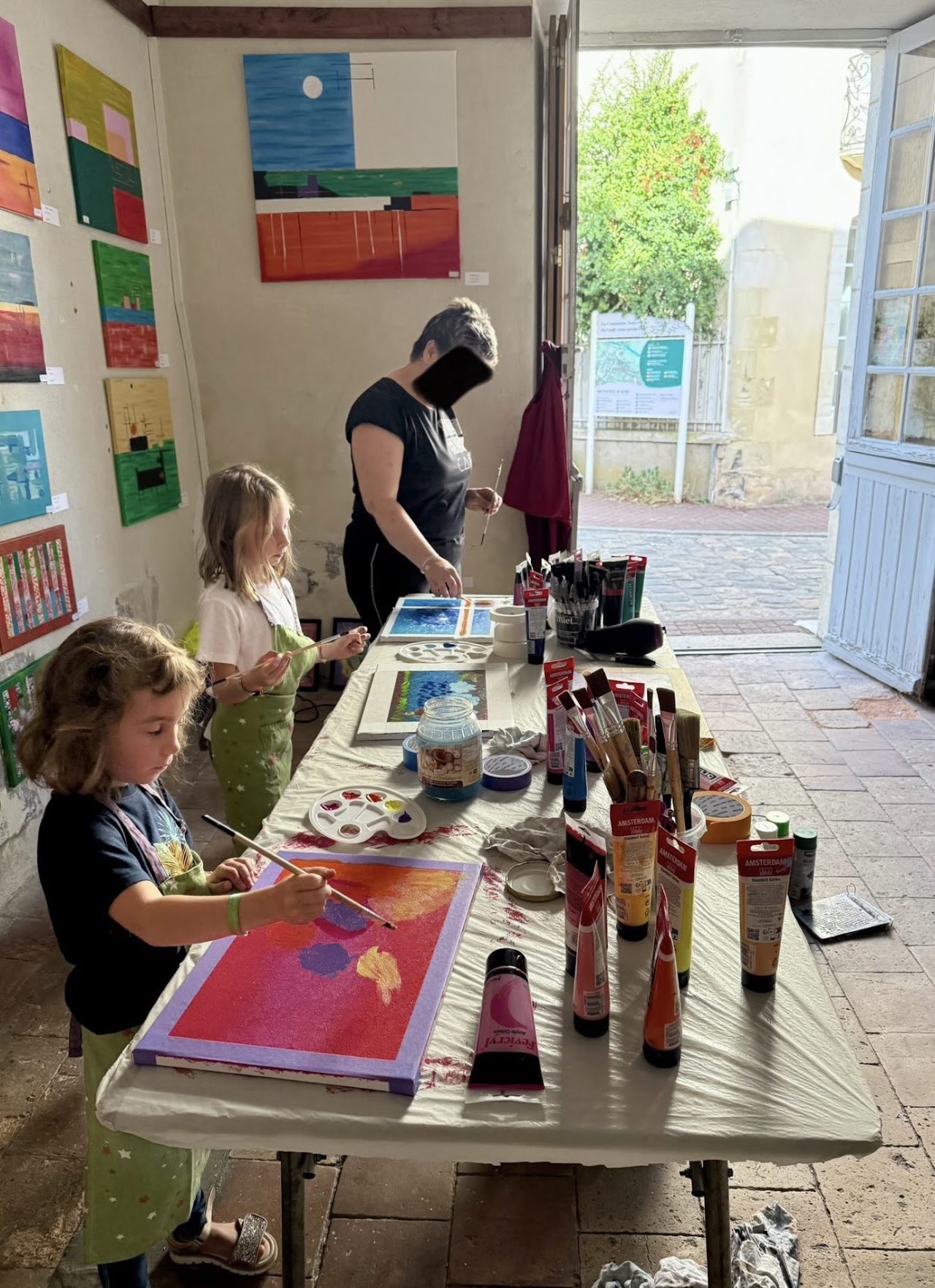 Participant peignant une toile colorée en atelier
